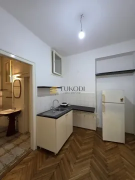 Small kitchen with a sink, refrigerator, and parquet flooring, overlooking the bathroom. - image 7