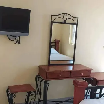 Furnished bedroom with a mirror and wall-mounted TV. - image 6