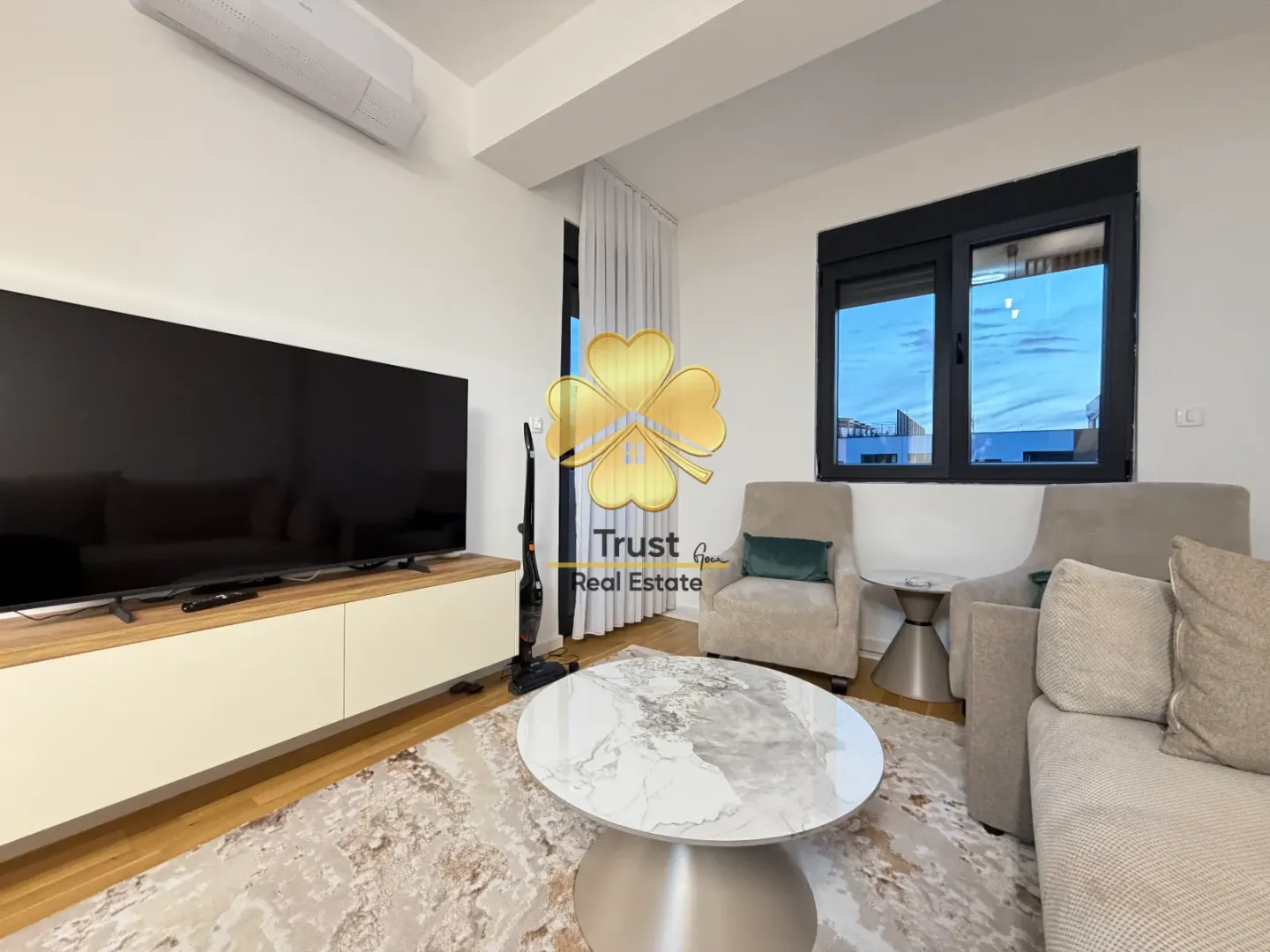 Living room with furniture, large TV and coffee table.