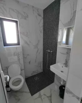 Savremeno opremljeno kupatilo sa tuš kabinom, umivaonikom i WC šoljom. - image 10