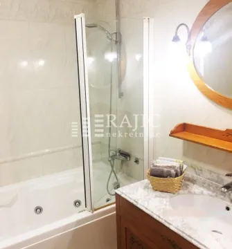Bathroom equipped with a bathtub, sink, and mirror. - image 6