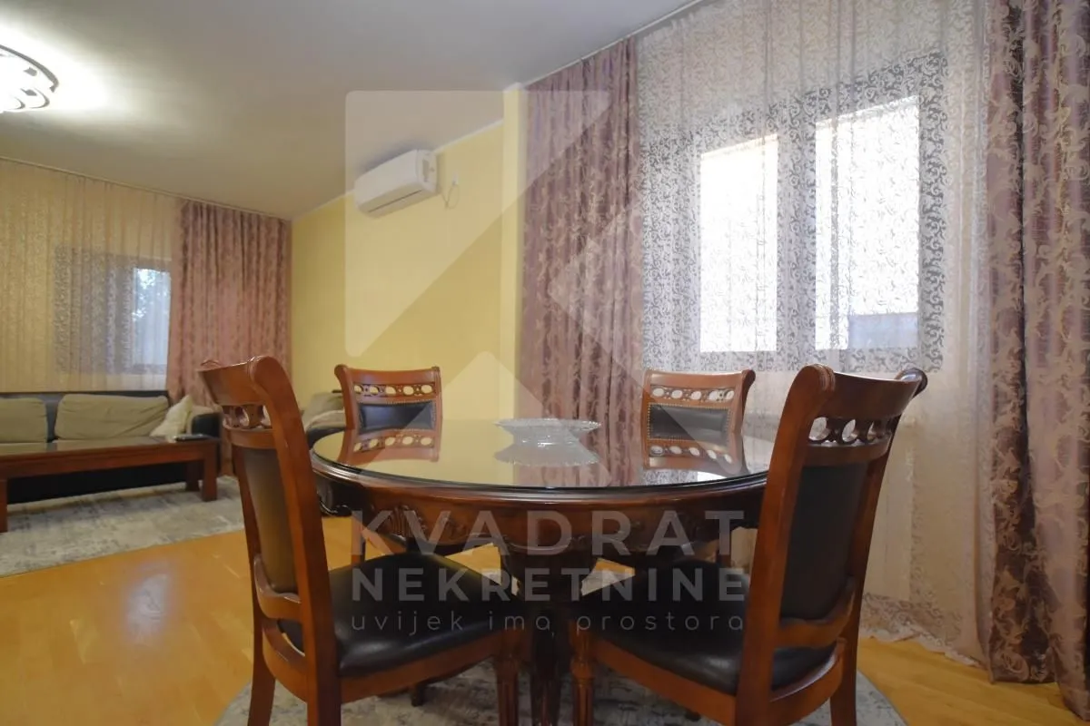 Dining area with a round table and chairs, connected to the living room.