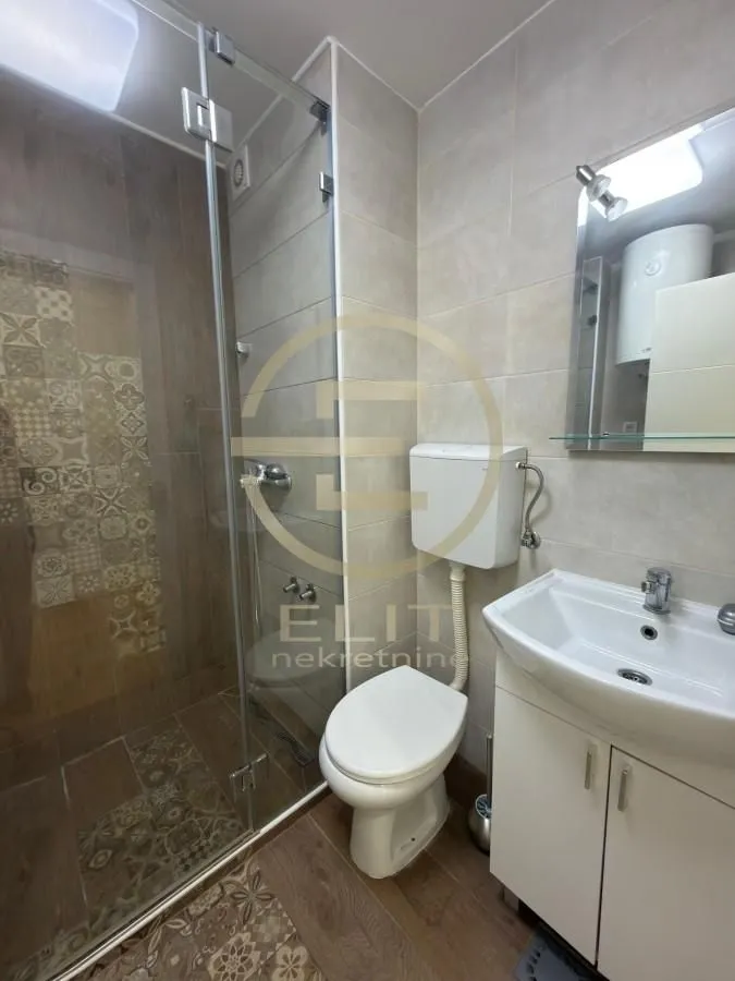 Kupatilo opremljeno tuš kabinom, umivaonikom i wc šoljom.