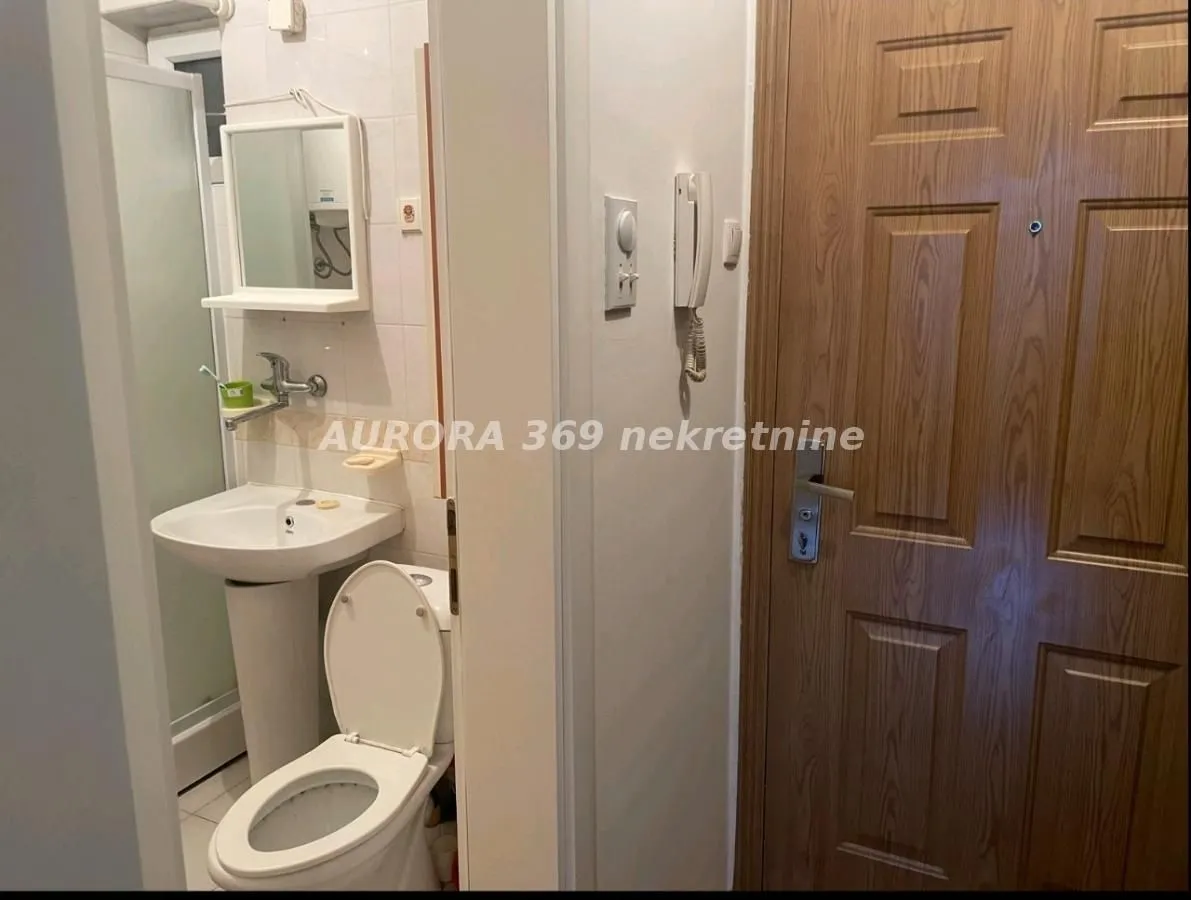 Pogled na kupatilo sa umivaonikom, WC šoljom i tuš kabinom.