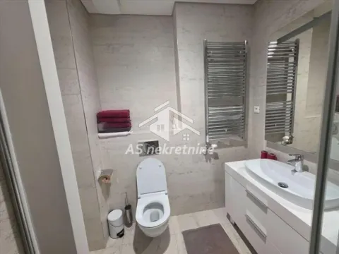 Modernly equipped bathroom with a washbasin, toilet, and towel warmer. - image 23