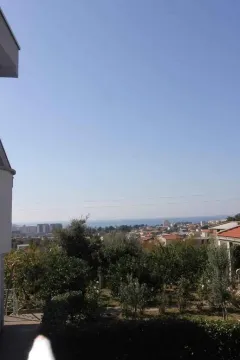 Pogled sa visine na okolno zelenilo, naselje i more u daljini. - image 4