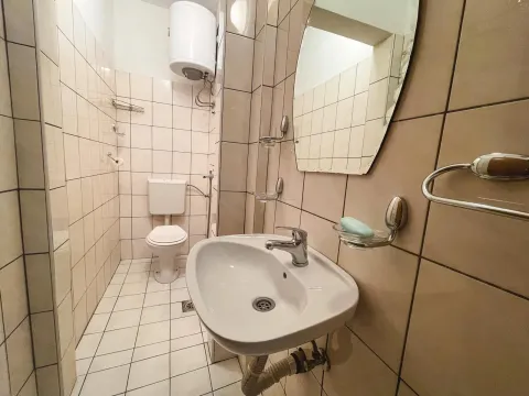 A simple bathroom featuring a sink, mirror, and toilet. - image 5