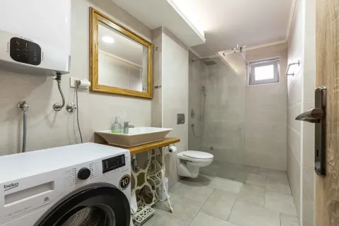 Savremeno opremljeno kupatilo sa tuš kabinom, umivaonikom i mašinom za veš. - image 3