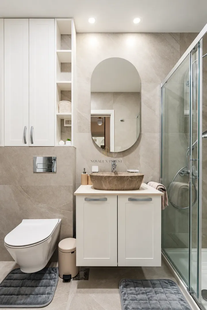 Modernly equipped bathroom with a basin, walk-in shower, and built-in cabinetry.