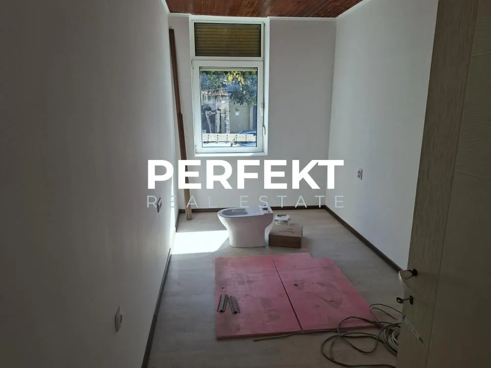 Prazna prostorija sa prozorom i WC šoljom na podu.