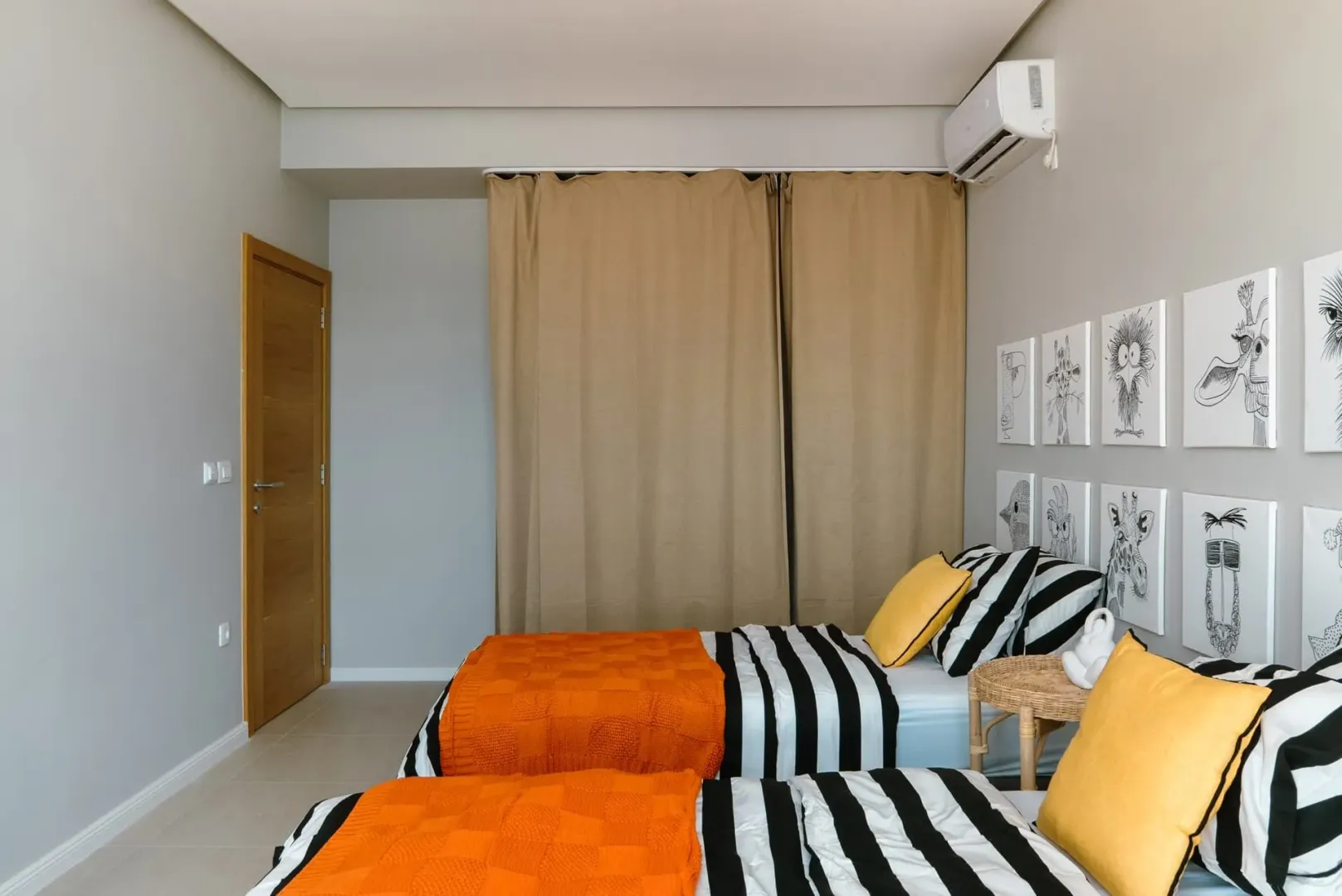 Moderna spavaća soba sa dva singl kreveta i dekorativnim slikama na zidu.