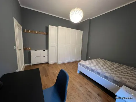 Furnished bedroom with a bed, wardrobe and desk. - image 8