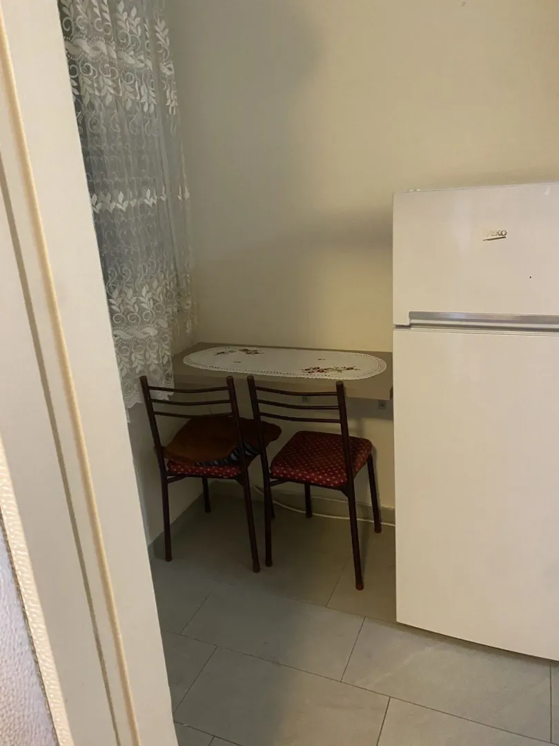 Trpezarijski kutak u kuhinji sa frižiderom.