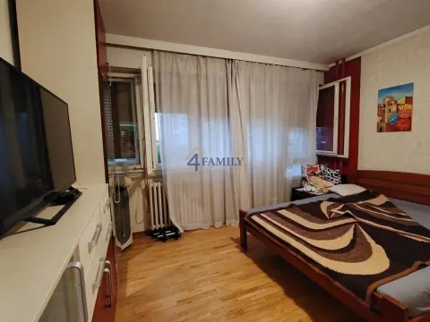 Spavaća soba sa bračnim krevetom, televizorom i prozorom prekrivenim zavesama. - image 5