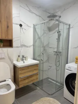 Moderno opremljeno kupatilo sa tuš kabinom, umivaonikom i veš mašinom. - image 12