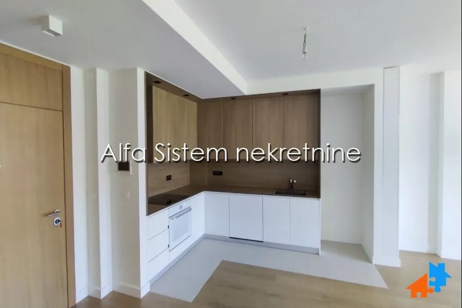 Modern corner built-in kitchen with white cabinets and wooden panels.