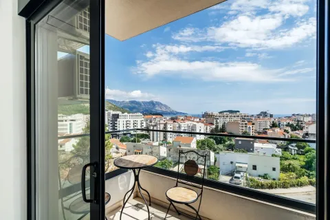Namješten balkon sa malim stolom i pogledom na grad i more. - image 10