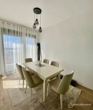 Trpezarija sa stolom i stolicama pored velikog prozora. - image 4