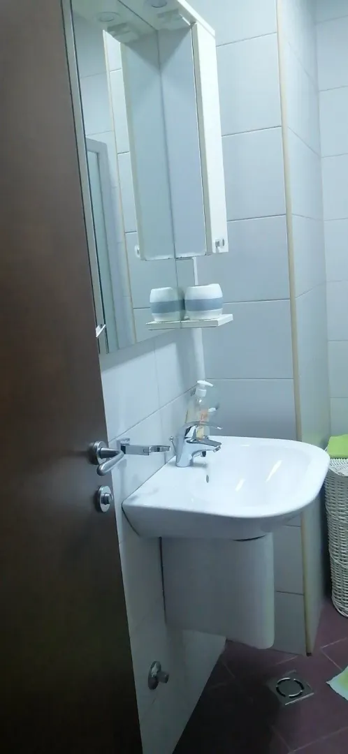 A simple bathroom with a white sink and a mirror.