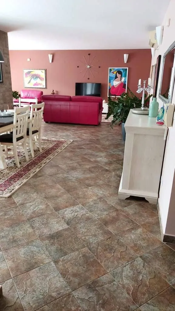 Prostrani dnevni boravak sa garniturom i trpezarijom.