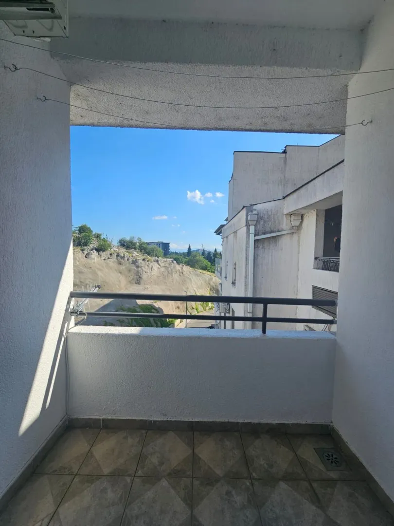 Pogled sa popločane terase na okolne zgrade i pejzaž.