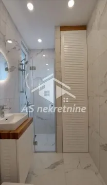 Moderno opremljeno kupatilo sa tuš kabinom i mermernim pločicama. - image 18