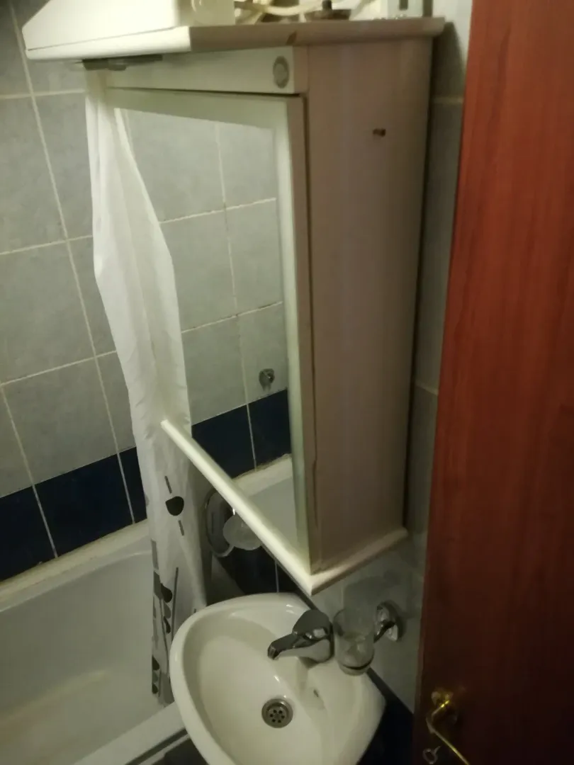 Kupatilo sa umivaonikom, ormarićem sa ogledalom i kadom.