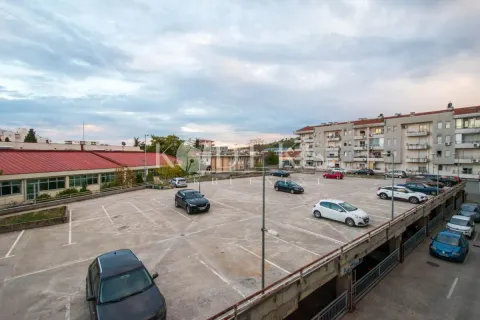 View of the parking lot in front of the residential building with parked cars. - image 2