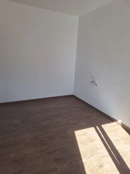 Prazna soba sa bijelim zidovima i drvenim podom. - image 2