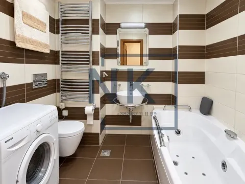 Bathroom equipped with a bathtub, washbasin, toilet, and washing machine. - image 7
