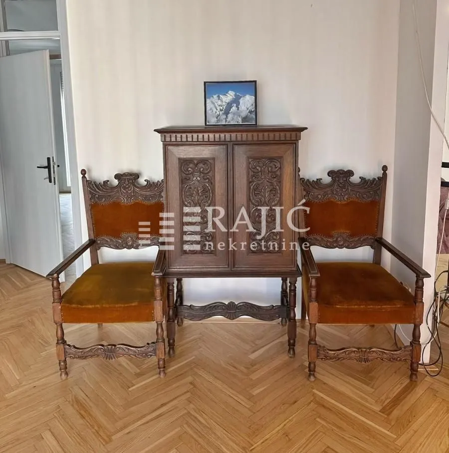 Living room with antique wooden furniture and parquet flooring.