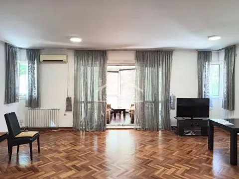 Dnevna soba sa drvenim parketom, televizorom i izlazom na terasu. - image 2