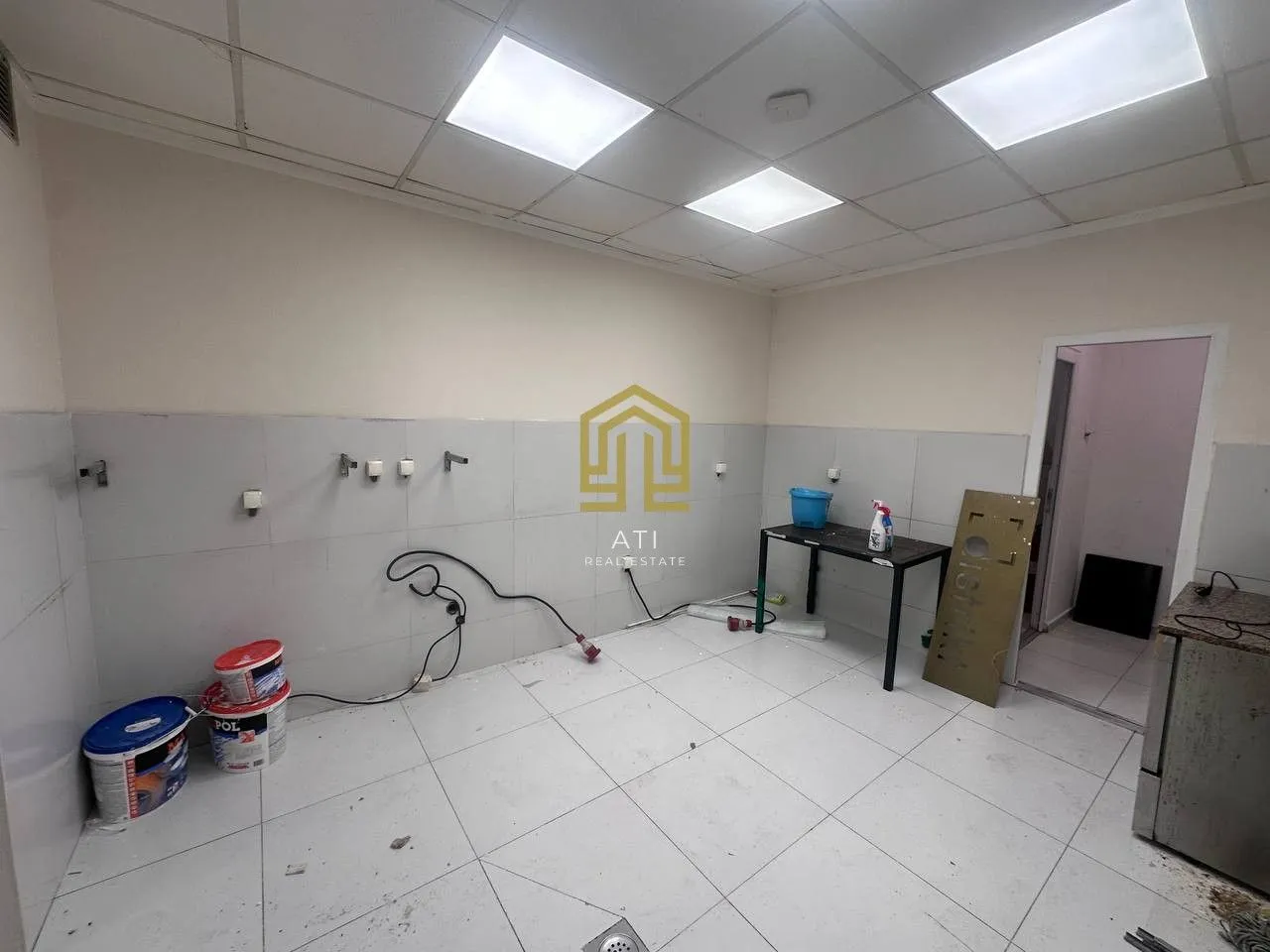 An empty room under renovation with tiled floor and walls.