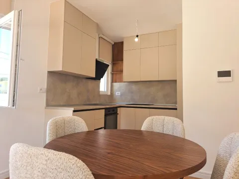 Moderna kuhinja sa bež elementima i trpezarijskim stolom sa stolicama. - image 11