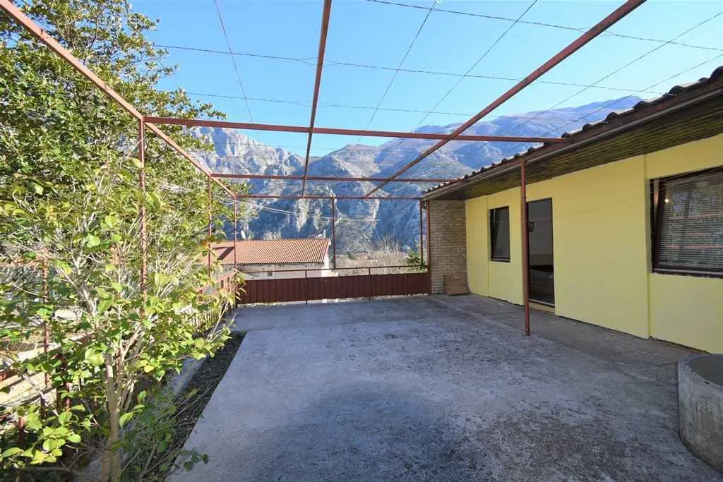 Spacious terrace with a metal pergola frame and mountain views.