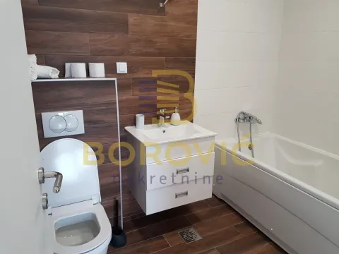Modern bathroom with a bathtub, washbasin, and toilet. - image 14