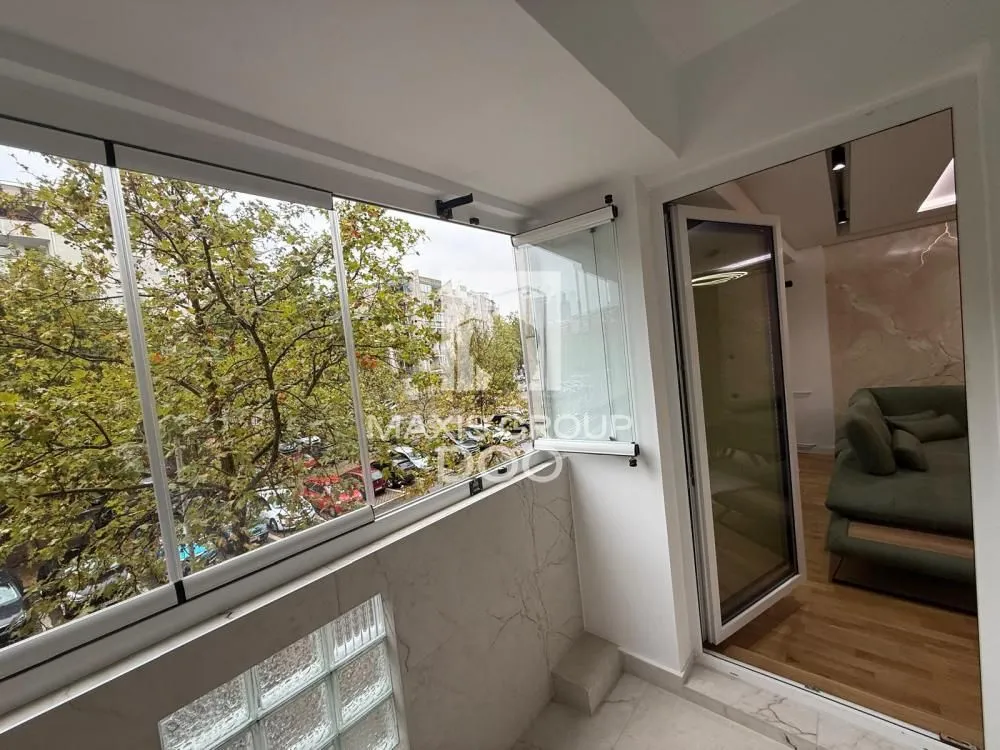 Glazed terrace with a view of greenery and access to the living room.