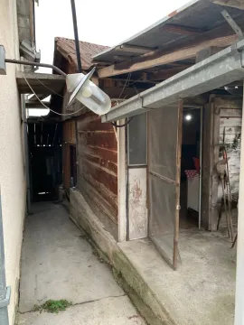 Spoljašnji izgled starijeg pomoćnog objekta sa drvenom fasadom i prolazom. - image 17