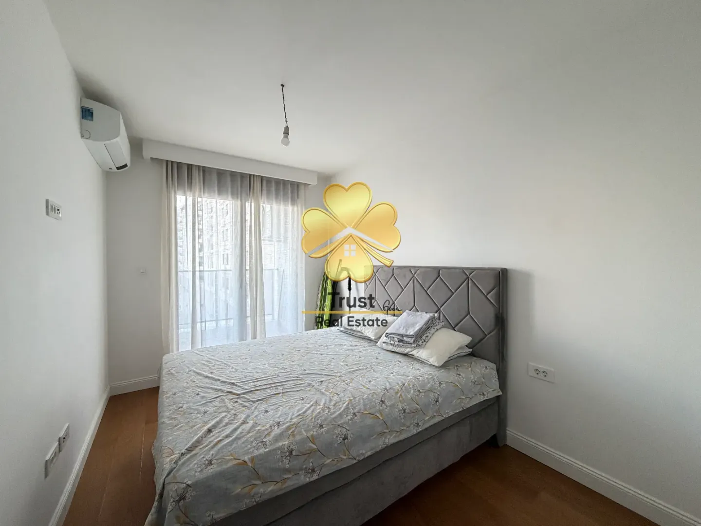 Bright bedroom with a double bed and a window.