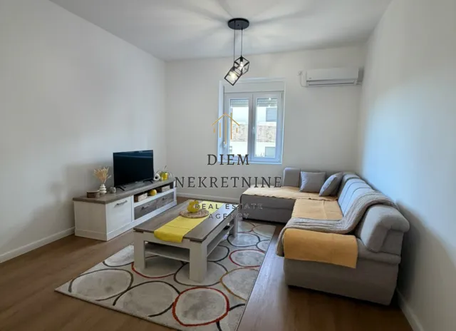 Living room with a sectional sofa, TV cabinet, and coffee table.