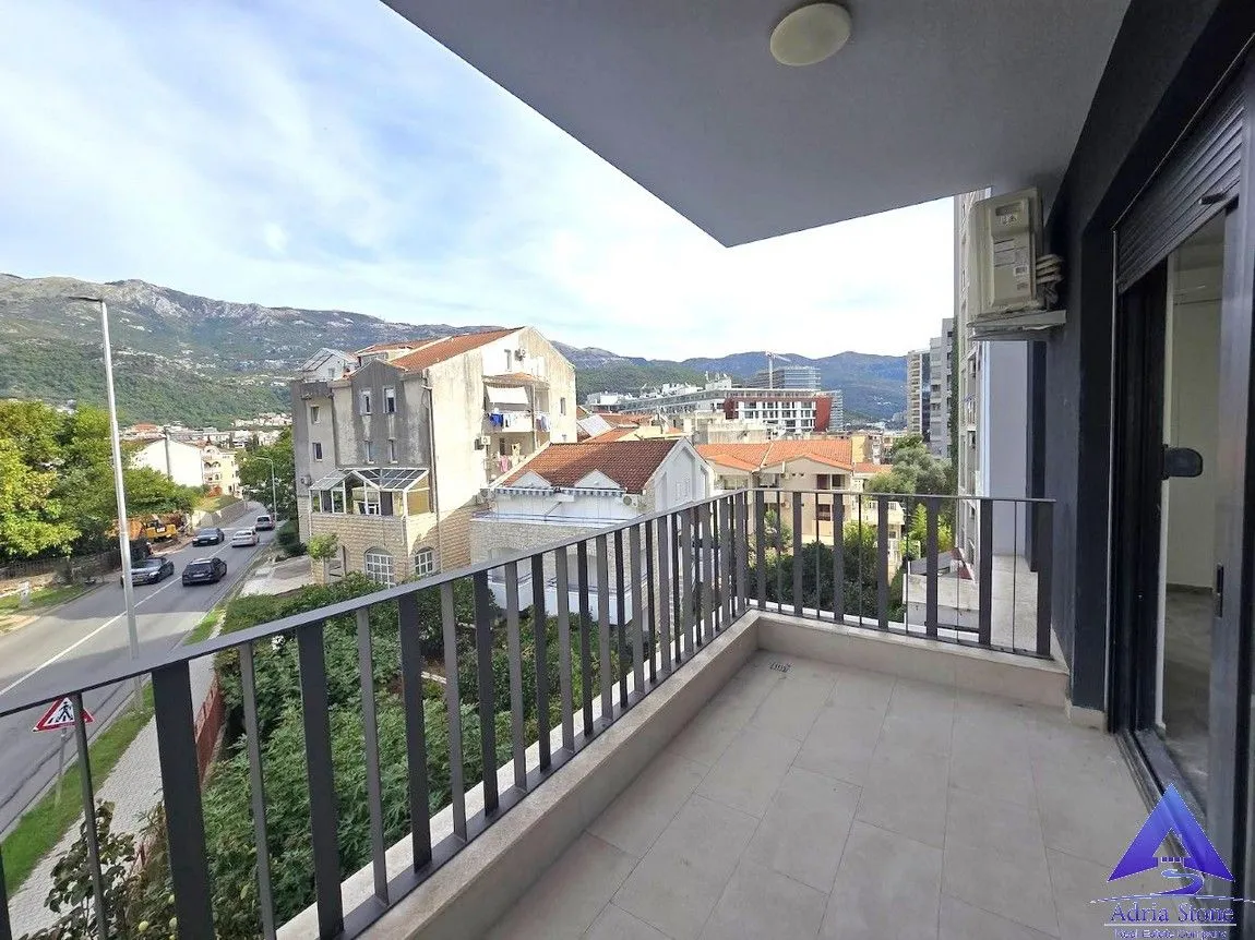 Natkriveni balkon sa pogledom na grad i okolne planine.