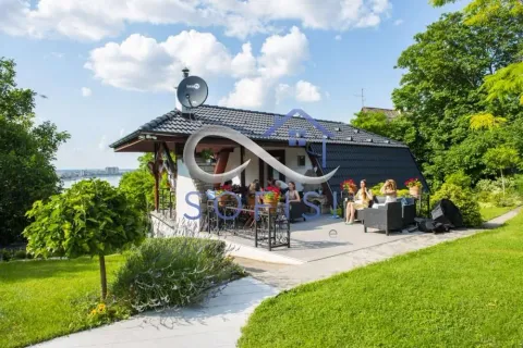 View of the exterior of the house with a landscaped yard and terrace. - image 13