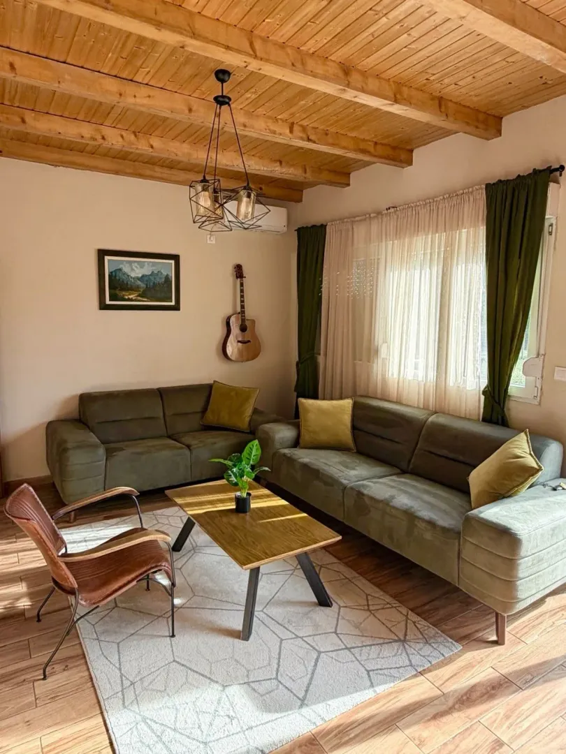 Living room with sofa, wooden ceiling and coffee table.