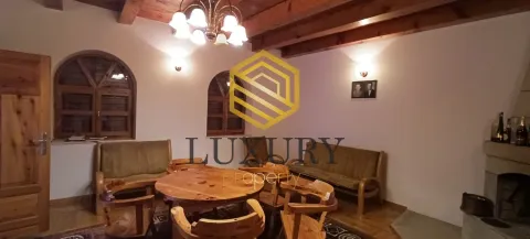Living room with wooden furniture and ceiling beams. - image 7