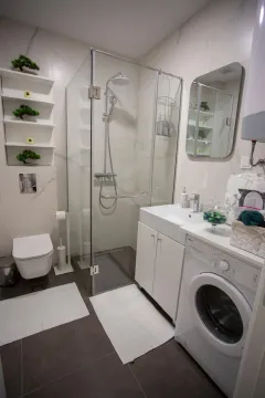 Moderno opremljeno kupatilo sa tuš kabinom, umivaonikom i veš mašinom. - image 11