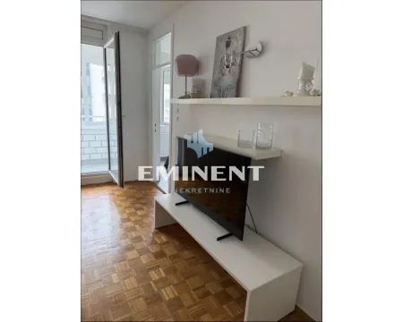 Living room with TV, shelving unit, and access to the terrace. - image 2