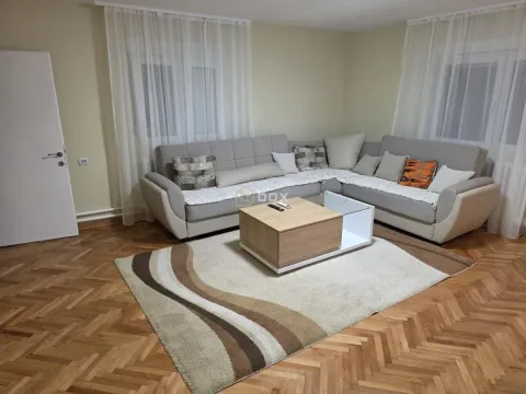 Dnevna soba sa ugaonom garniturom, stočićem i parketom na podu. - image 2