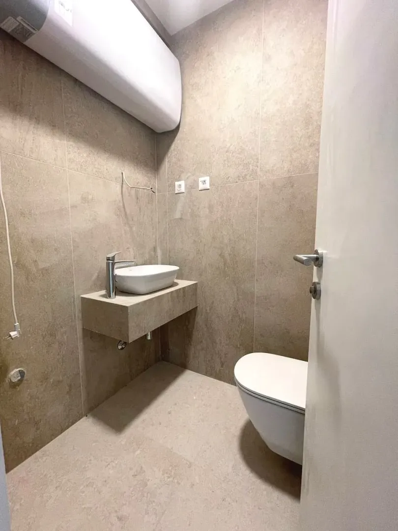 Smaller bathroom with a sink and a toilet.