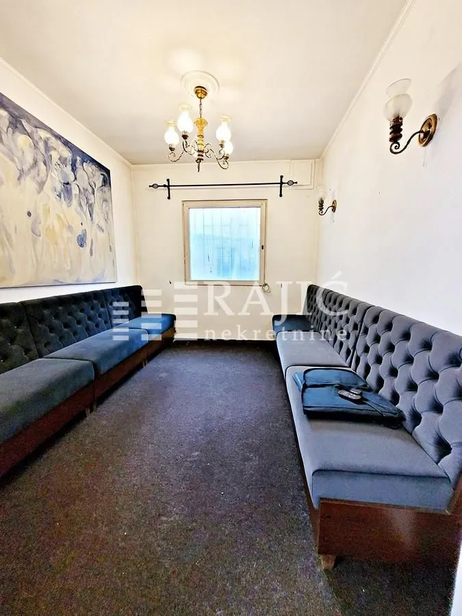 Living room with upholstered benches and a large artwork on the wall.