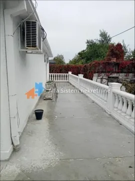 Spacious terrace with a concrete floor and a white balustrade along the house. - image 4